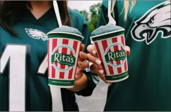  ?? PHOTOS COURTESY THE EAGLES/RITA’S ITALIAN ICE ?? Above, Rita’s Italian Ice has rolled out a new summer flavor meant to honor the Eagles. Called “Go Birds!” the flavor is a mix of apple and pear and is mixed to resemble the Eagles green. At left, Eagles Defensive Tackle Kevin Wilkins and the official Rita’s Water Ice Kid deliver Rita’s after practice. To honor the Eagles, Rita’s is offering a new summer flavor called “Go Birds!” a mix of apple and pear.