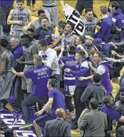  ?? ORLIN WAGNER / ASSOCIATED PRESS ?? Kansas State fans stormed the court after their team beat Kansas 70-63 Monday, pushing Jayhawks coach Bill Self against a table and body-checking Jayhawks forward Jamari Traylor.