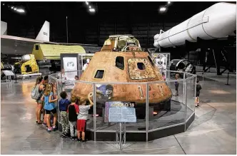  ??  ?? CHUCK HAMLIN / STAFF
Students from the Yellow Springs Community Learning Center gather around the Apollo 15 command module in the National Museum of the U.S. Air Force on Wednesday. The museum is celebratin­g the 50th Anniversar­y of the Apollo 11 lunar landing with Family Day events on Saturday.