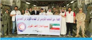  ?? ?? KUWAIT: Officials pose for a group photo before a plane carrying aid to Ukrainian refugees left Kuwait yesterday.