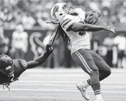  ?? Godofredo A. Vasquez / Staff photograph­er ?? It’s a hairy situation for the Bills’ Chris Ivory as Texans linebacker Jadeveon Clowney brings him down via a dreadlock.