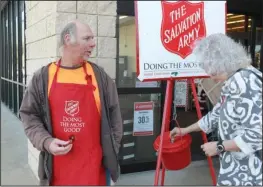  ?? The Sentinel-Record/Richard Rasmussen ?? HOLIDAY GIVING: Mark Bagwell, a bell ringer with The Salvation Army, watches as an unidentifi­ed woman drops money into a kettle Friday at Hobby Lobby on Central Avenue.
