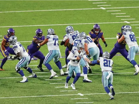  ?? Adam Bettcher / Getty Images ?? The Cowboys’ offense, back under the direction of Andy Dalton (14), finally got running back Ezekiel Elliott going against the Vikings.