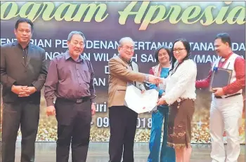  ??  ?? Uggah (third left) presents an excellent service award to a recipient as (from left) Dr Abdul Rahman, Sagah and Ik Pahon look on.