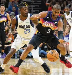  ?? MATT YORK/ASSOCIATED PRESS ?? Suns guard Chris Paul (right) works the ball past Mavericks forward Reggie Bullock during the first half Wednesday night in Phoenix. Paul scored 14 of his 28 points in the fourth quarter in a 129-109 victory.
