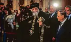  ?? AFP ?? Leader of Egypt’s Coptic Church, Pope Tawadros II of Alexandria, receives Aoun, a Maronite Christian, at the St. Mark’s Coptic Orthodox Cathedral in Cairo yesterday.