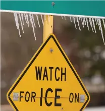  ?? Melissa Phillip / Staff photograph­er ?? Icicles hang from a Watch For Ice On Bridge sign along Cutten Road near Bourgeois Road in Houston.