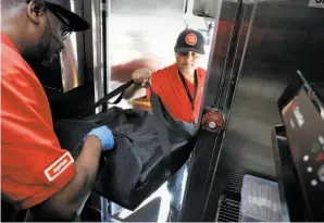  ??  ?? Morris hands off a pizza to Deepak Dabadi in Palo Alto. Zume Pizza uses robotic pizza-makers and smart ovens inside a truck to serve up cooked-to-order pizzas.