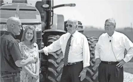  ?? PHOTOS BY ANDREW HARNIK/AP ?? President Joe Biden listens as he stands with O’connor Farms owners, Jeff O’connor and Gina O’connor, and Agricultur­e Secretary Tom Vilsack, right, at the farm Wednesday in Kankakee, Ill.