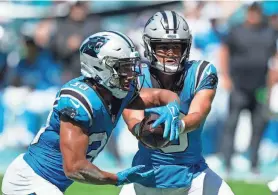  ?? WILFREDO LEE/AP ?? Panthers quarterbac­k Bryce Young (9) hands the ball to running back Chuba Hubbard (30) during the first half against the Dolphins on Sunday in Miami Gardens, Fla.