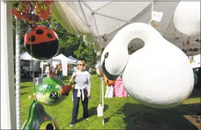  ?? Christian Abraham / Hearst Connecticu­t Media ?? Sonia Gabiola, of Sagaponack, N. Y., strolls past art and crafts tents with handcrafte­d items for sale during Mary Taylor Memorial United Methodist Church’s annual two- day craft fair on the downtown Milford green on Friday. The swan on display in the...