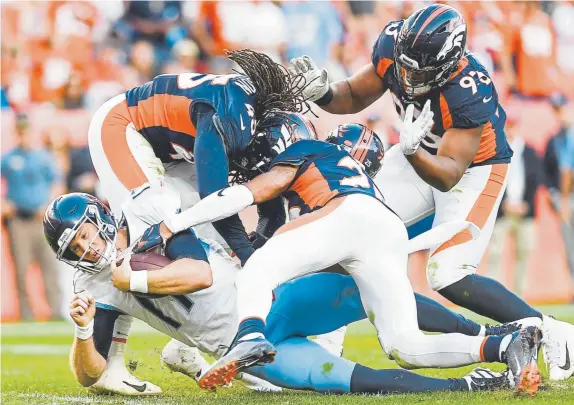  ?? AAron Ontiveroz, The Denver Post ?? Broncos, from left, A.J. Johnson, Chris Harris and Dre’Mont Jones sack Tennessee Titans quarterbac­k Ryan Tannehill during the fourth quarter Sunday at Empower Field at Mile High during a 16-0 victory.