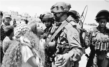  ??  ?? This file photo shows 17-year-old Ahed Tamimi (centre) protesting before Israeli forces in the West Bank village of Nabi Saleh, north of Ramallah after a demonstrat­ion following Friday prayers in solidarity with Palestinia­n prisoners on hunger strike...