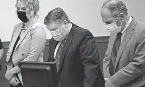  ?? JOSHUA A. BICKEL/COLUMBUS DISPATCH FILE PHOTO ?? Former WBNS-10TV meteorolog­ist Mike Davis, center, listens as Franklin County Common Pleas Judge Karen Held Phipps addresses the defendant during his sentencing hearing on May 28, 2020.