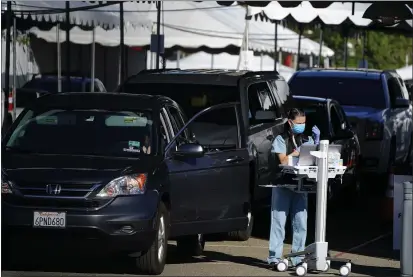  ?? GREGORY BULL — THE ASSOCIATED PRESS ?? People wait in cars for a vaccinatio­n against the coronaviru­s on Monday in San Diego.