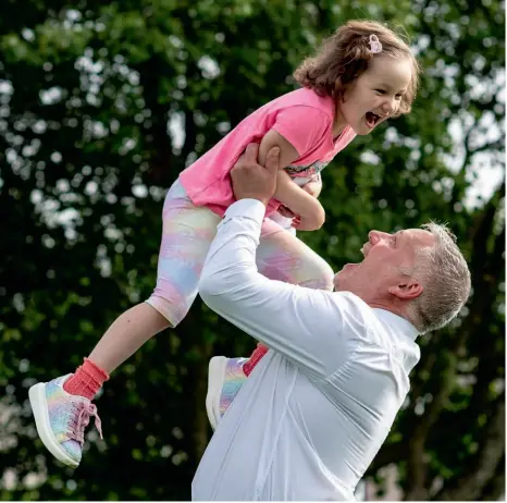  ??  ?? Uplifting: Mila was separated from dad Scott ( above) and sister Jodi (left) last year while shielding during lockdown. A touching photo of her kissing her dad through a window during this period (below) was chosen as one of 100 images f e a t u re d in the Duchess’s book Hold Still , comprising portraits of life in the UK during lockdown, which went on to become a bestseller