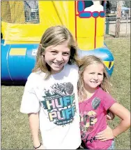  ??  ?? Sadee Depriest and Jalyn Ireland are pretty happy after spending some time in the bouncy houses at the Ozark Orchard Festival.