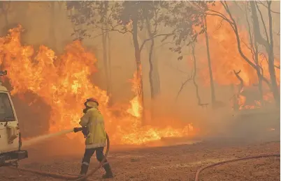  ??  ?? A firefighte­r battles a bushfire outside Wooroloo, near Australia’s city of Perth. — AFP