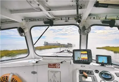  ?? KARL MERTON FERRON/BALTIMORE SUN PHOTOS ?? The Great Fox Island, a disappeari­ng key near Crisfield, stretches before Larry Laird as he navigates a jet boat on Wednesday.