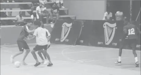  ??  ?? Kevon Lythcott (left) of MBK All-Stars attempting to dribble two Champion Boys defenders at the National Gymnasium in the Guinness ‘Cage’ Football Championsh­ip