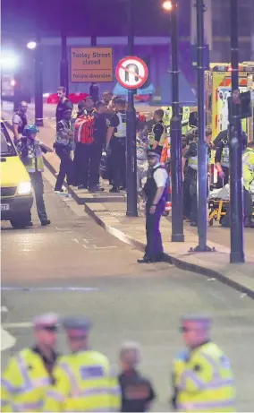  ??  ?? > Emergency personnel tend to wounded on London Bridge as police