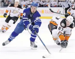  ??  ?? Leafs centre Auston Matthews battles for the puck with Ducks centre Rickard Rakell during second-period action in Toronto.