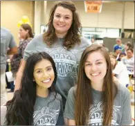  ??  ?? From left, Kenia Munoz, Erin Whitley, standing, and Montana Wallace, all of Seacy, pose for a photo while volunteeri­ng.