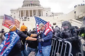  ??  ?? UNA TURBA trata de abrirse paso entre una valla policial en el capitolio de Washington