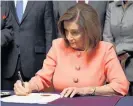  ??  ?? Nancy Pelosi signs the articles.