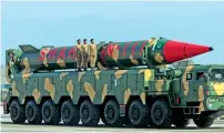  ?? AFP, Reuters ?? An F-16 fighter jet flies past during the military parade; and, right, military personnel stand beside a Shaheen III surface-to-surface ballistic missile. —