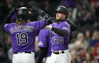  ?? David Zalubowski, The Associated Press ?? Colorado’s Charlie Blackmon, left, congratula­tes Ryan Mcmahon for his three-run home run against the Cincinnati Reds during the fifth inning Friday in Denver.