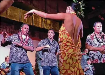  ?? Joseph Duarte / Houston Chronicle ?? While the bowl trip is considered a business trip, University of Houston football players, like Garrett Davis, left, and Trevon Bradley, who participat­ed in a hula demonstrat­ion during Wednesday night’s Hawaii Bowl luau, also got to enjoy some time off.