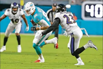  ?? CHARLES TRAINOR JR. / MIAMI HERALD ?? Miami’s tight end Mike Gesicki catches a pass in the second quarter as Baltimore’s Tony Jefferson closes in Saturday. It was Gesicki’s first catch of the preseason.