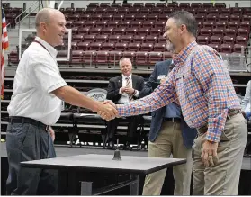  ?? Sierra Bush/Siloam Sunday ?? Steve Avery (right), transporta­tion director, and Tim Hornbuckle, intermedia­te school principal, shake hands before facing off in a round of Family Feud, during a back to school breakfast for teachers and other school officials hosted by the Siloam Springs Chamber of Commerce on Wednesday.