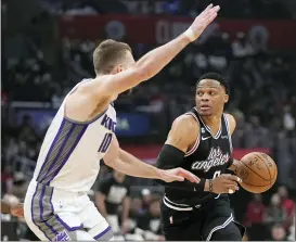  ?? MARK J. TERRILL — THE ASSOCIATED PRESS ?? Los Angeles Clippers guard Russell Westbrook, right, drives by Sacramento Kings forward Domantas Sabonis during the first half of Friday’s game in Los Angeles.