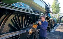  ?? ANDREW PM WRIGHT ?? Flying Scotsman oiled by support crew fitter Ben Chapman at Swanage following its arrival on October 18.