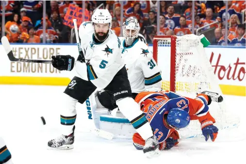  ??  ?? David Desharnais (13) of the Edmonton Oilers battles against David Schlemko (5) of the San Jose Sharks in Game Five of the Western Conference first round during the NHL Stanley Cup payoffs at Rogers Place in Edmonton, Alberta, on Thursday night. (AFP)