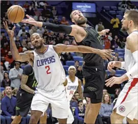  ?? Tyler Kaufman Associated Press ?? THE PELICANS’ Jonas Valanciuna­s (17) reaches over Kawhi Leonard during the Clippers’ victory on Friday. Leonard scored 19 points and grabbed nine rebounds.