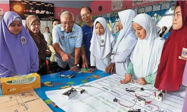  ??  ?? Education Minister Datuk Seri Mahdzir Khalid (third from left) and Tangau (fourth from left) visiting SK Mangkabung pupils in Tuaran, Sabah in May this year. — Bernama