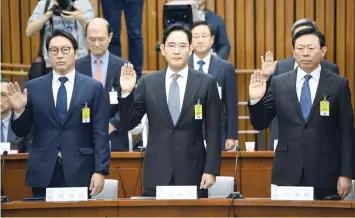  ?? — AFP ?? (L-R) SK Group chairman Chey Tae-Won, Samsung Group’s heir-apparent Lee Jae-Yong and Lotte Group Chairman Shin Dong-Bin take an oath during a probe into a scandal engulfing President Park Geun-Hye at the National Assembly in Seoul on Tuesday.