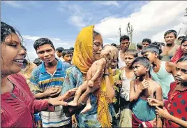  ?? REUTERS ?? A Rohingya refugee woman cries as she holds her 40dayold son, who died as a boat capsized on the shore of Shah Porir Dwip in Teknaf, Bangladesh, on Thursday.