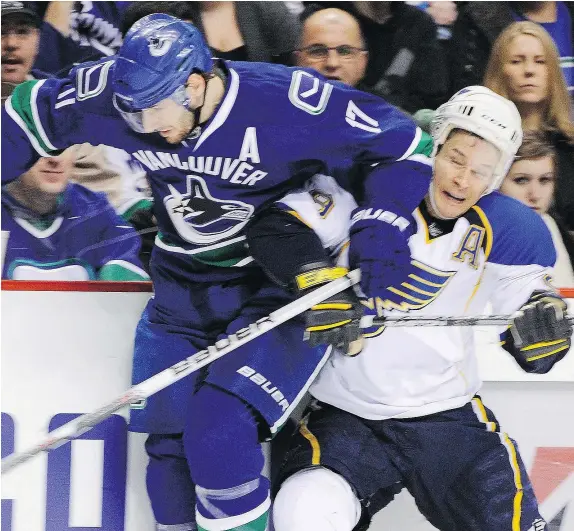  ?? RIC ERNST/PNG FILES ?? Paul Kariya, right, then with the St. Louis Blues, takes a hit from the Vancouver Canucks Ryan Kesler in the 2009-10 season. The new Hockey Hall of Fame member says the NHL is on the right path in dealing with concussion­s but more must be done.