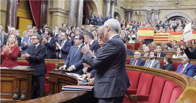  ??  ?? BARCELONA: Catalan deputies of the PPC (Popular Party of Catalonia) hold up Spanish and Catalan flags following the vote on a proposed resolution to secede from the rest of the country during a session at the Catalan Parliament in Barcelona yesterday.