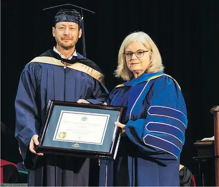  ?? LEONORA ANDRE/MOUNT ROYAL UNIVERSITY ?? Paul Brandt receives his honorary degree from Susan Mallon, chair of the Mount Royal University Board of Governors, on Friday. Brandt spoke about the dangers of the internet and “trial by social media” as he accepted the honour.