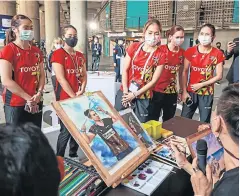  ?? ?? HEY, THAT’S US: The national Thai female badminton team look at portraits of themselves before they went on display at the ‘Beauty of Opportunit­y’ exhibition at Impact Muang Thong Thani.