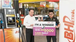  ??  ?? Azizul (left) presenting the RM5,000 prize to Khairul at BHPetrol Taman Tun Dr Ismail, Kuala Lumpur.