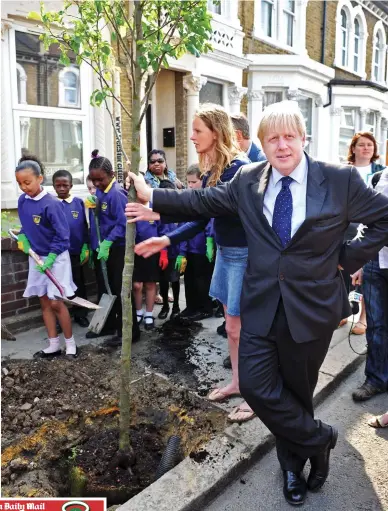  ??  ?? Environmen­tal champion: Boris Johnson planting a tree