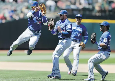  ?? BEN MARGOT/THE ASSOCIATED PRESS ?? Toronto Blue Jays’ Josh Donaldson, left, avoids a collision with Justin Smoak, second from left, after Smoak caught the ball in Toronto’s win against the Oakland Athletics on Sunday.