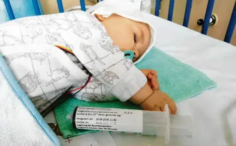  ?? Foto: Marina Mantel, dpa ?? Der einjährige Michael schläft, während er eine Injektion mit dem Genpräpara­t Zolgensma gegen spinale Muskelatro­phie bekommt.