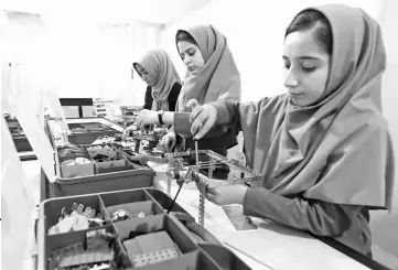  ??  ?? Members of Afghan robotics girls team which was denied entry into the United States for a competitio­n, work on their robots in Herat province, Afghanista­n. — Reuters photo